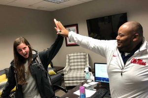 Dr. Sovent Taylor giving student a big high five in congratulations