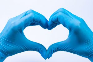 hands in blue gloves making a heart shape